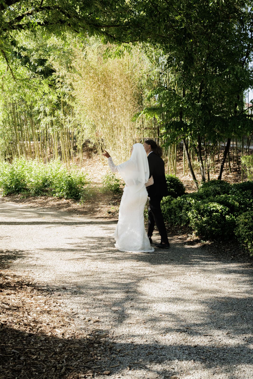 Les mariés dans l'allée d'un jardin de bambous